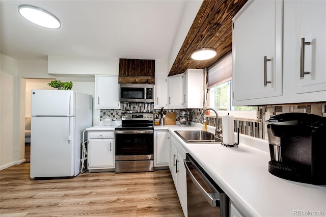 kitchen with light hardwood / wood-style flooring, white cabinets, appliances with stainless steel finishes, and sink