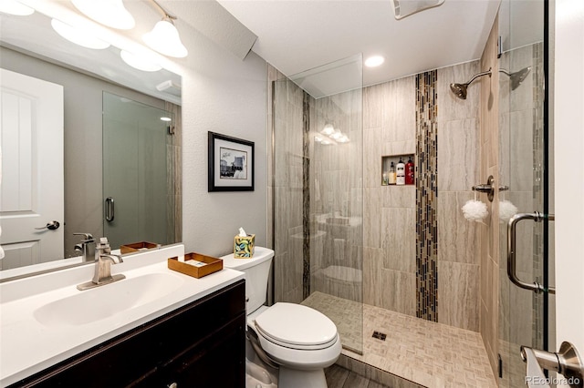 bathroom with walk in shower, vanity, and toilet