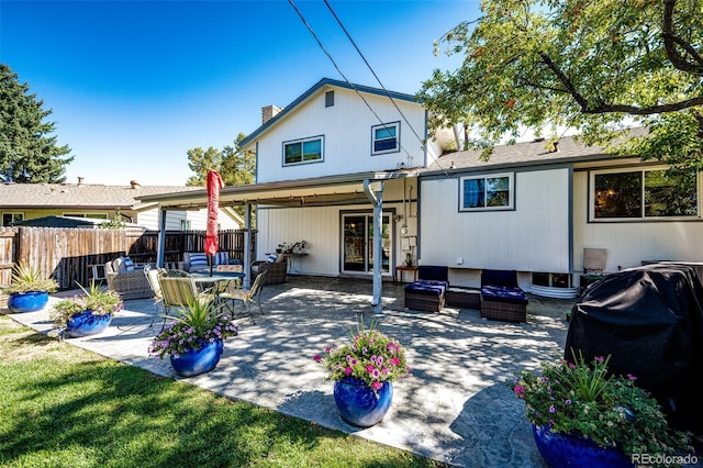 rear view of house with a yard, an outdoor living space, and a patio area