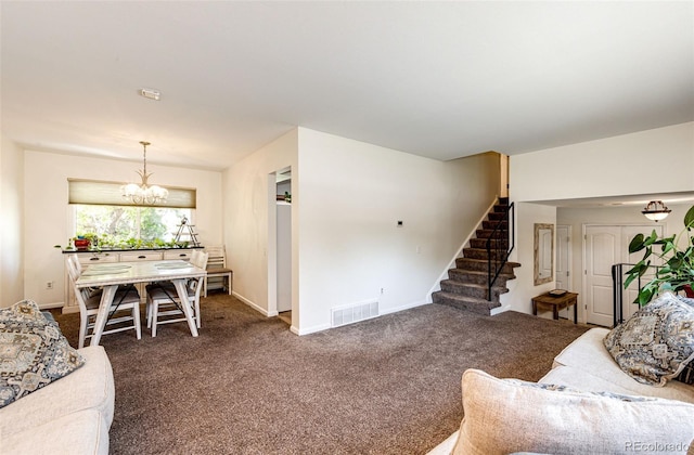 living room featuring an inviting chandelier and dark carpet