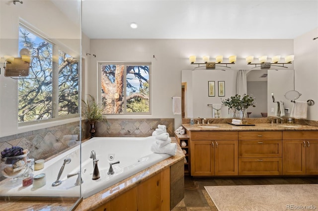 full bath featuring a sink, a whirlpool tub, and double vanity