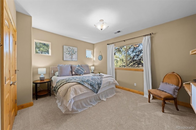 carpeted bedroom featuring baseboards and visible vents