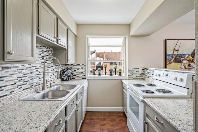 kitchen with tasteful backsplash, white appliances, sink, gray cabinets, and dark hardwood / wood-style floors