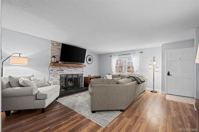 living room with hardwood / wood-style flooring, a fireplace, and a textured ceiling