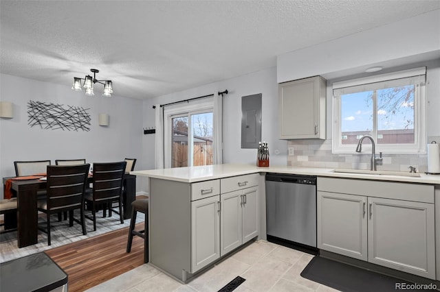 kitchen with dishwasher, a healthy amount of sunlight, kitchen peninsula, and sink