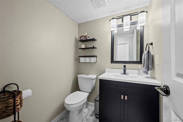 bathroom with vanity, a textured ceiling, toilet, and tile patterned flooring