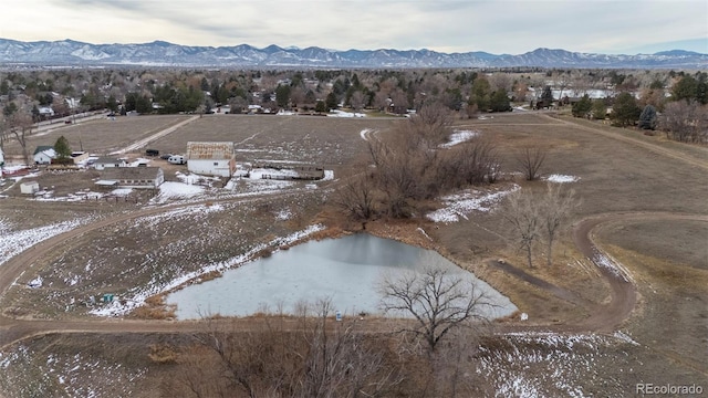 snowy aerial view with a water and mountain view