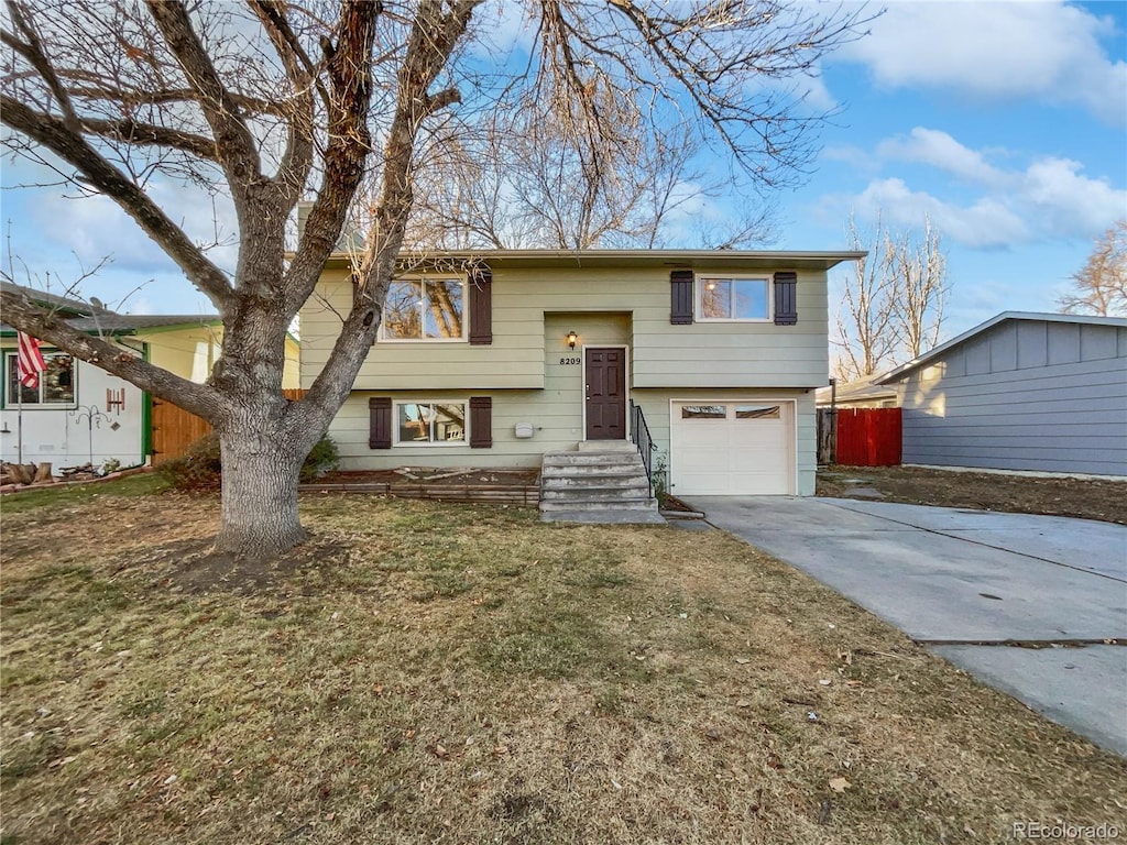 raised ranch with a garage and a front yard