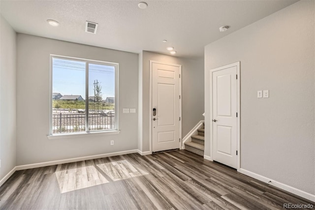 entrance foyer featuring a textured ceiling and dark hardwood / wood-style flooring