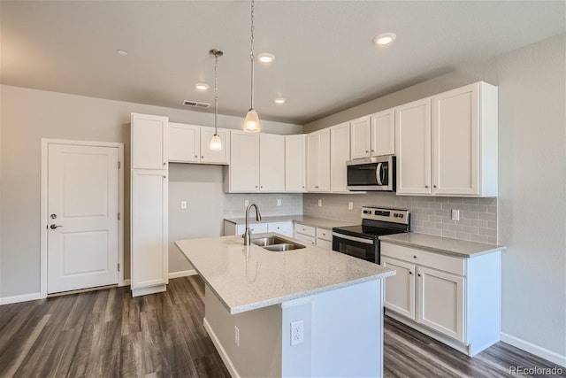 kitchen featuring sink, light stone counters, appliances with stainless steel finishes, an island with sink, and white cabinets