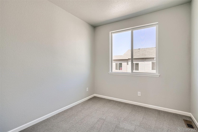 carpeted spare room featuring a textured ceiling