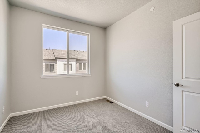 carpeted spare room featuring a textured ceiling