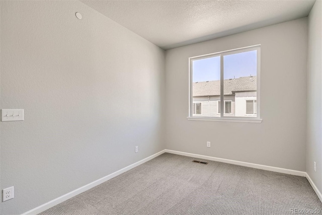 unfurnished room with carpet flooring and a textured ceiling