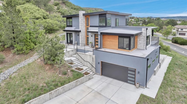 202 October Pl, Castle Rock, CO 80104 - contemporary home featuring stucco siding, driveway, a garage, stone siding, and a chimney