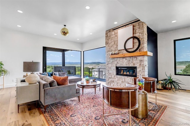 202 October Pl, Castle Rock, CO 80104 - living room with light wood-style flooring, a stone fireplace, recessed lighting, and baseboards