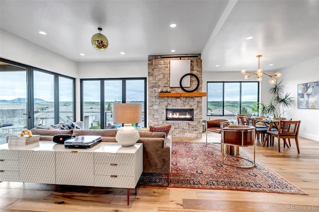 202 October Pl, Castle Rock, CO 80104 - living room with a fireplace, wood finished floors, recessed lighting, a chandelier, and baseboards