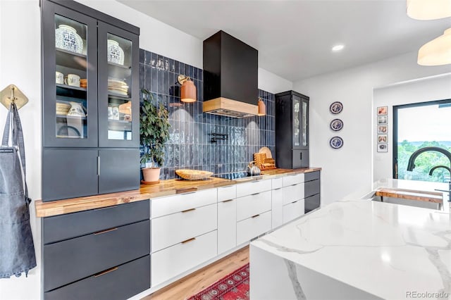 202 October Pl, Castle Rock, CO 80104 - kitchen with a sink, glass insert cabinets, light stone countertops, light wood-type flooring, and tasteful backsplash