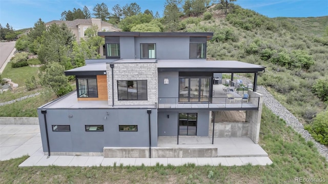 202 October Pl, Castle Rock, CO 80104 - back of house featuring stucco siding, a balcony, a patio, and stone siding