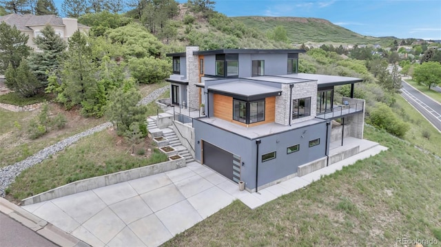202 October Pl, Castle Rock, CO 80104 - view of front of home featuring a balcony, concrete driveway, stone siding, stucco siding, and a garage