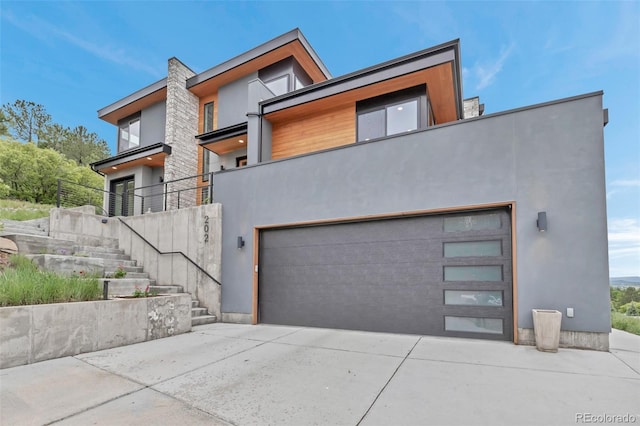 202 October Pl, Castle Rock, CO 80104 - contemporary house with stucco siding, driveway, an attached garage, and stairs