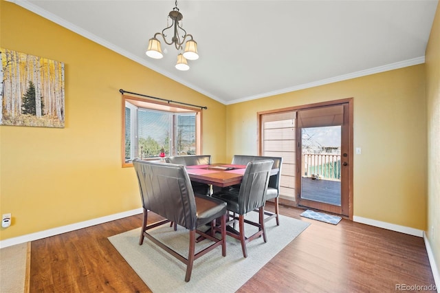 dining space with crown molding, vaulted ceiling, and hardwood / wood-style floors