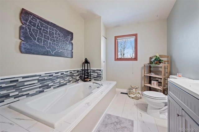 bathroom featuring toilet, vanity, and a tub to relax in