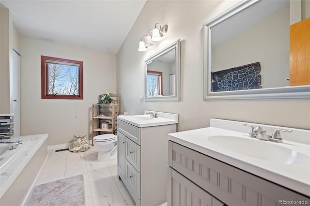 bathroom with vanity, a tub to relax in, and toilet