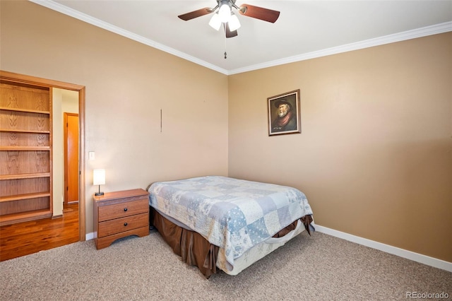 carpeted bedroom with ornamental molding and ceiling fan