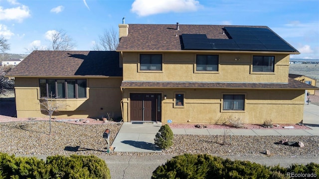 view of front of property featuring solar panels