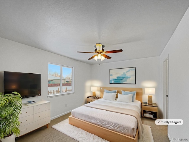 bedroom featuring ceiling fan, carpet floors, and a textured ceiling