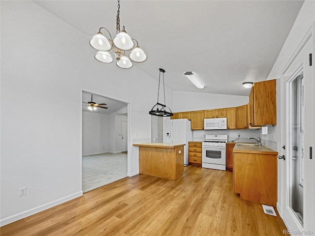 kitchen featuring sink, vaulted ceiling, kitchen peninsula, pendant lighting, and white appliances