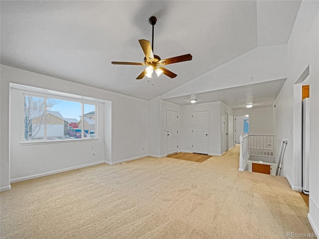 carpeted empty room with ceiling fan and lofted ceiling