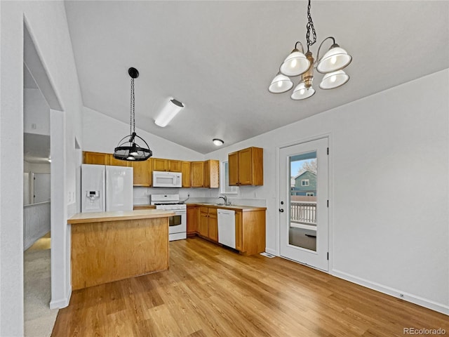 kitchen featuring white appliances, lofted ceiling, decorative light fixtures, and kitchen peninsula