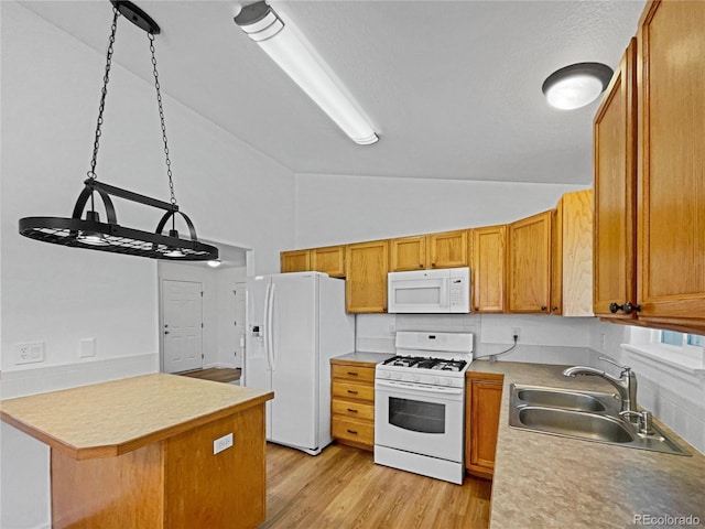 kitchen featuring sink, hanging light fixtures, white appliances, light hardwood / wood-style floors, and backsplash