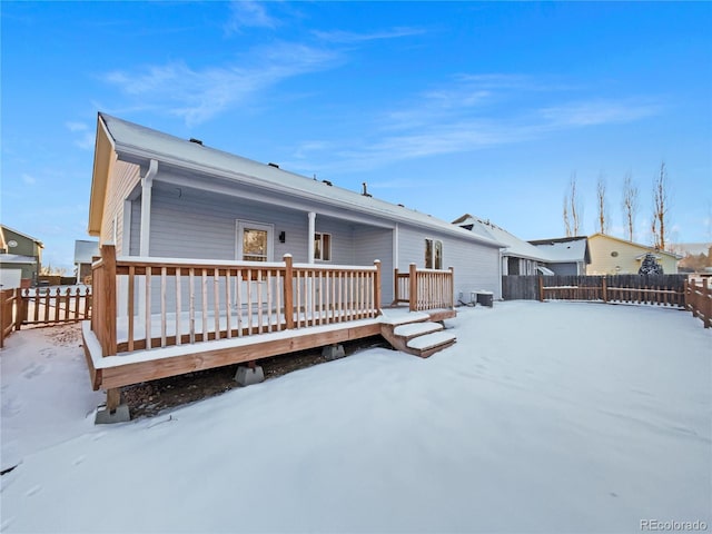 snow covered rear of property featuring a deck