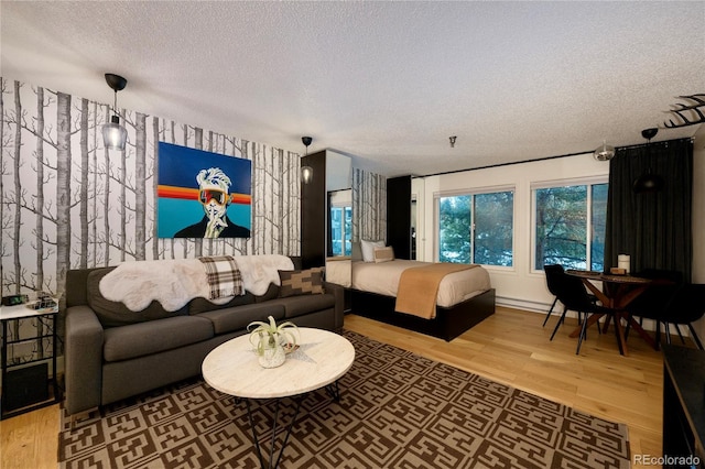 bedroom with hardwood / wood-style floors, a textured ceiling, and a baseboard radiator