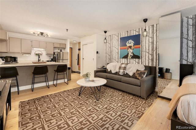 living room with light hardwood / wood-style floors and sink