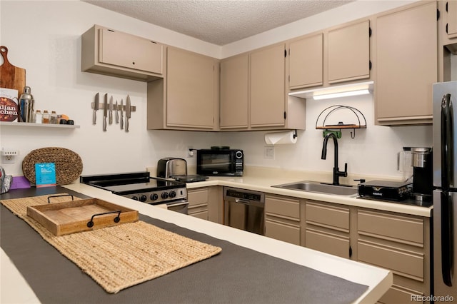 kitchen featuring a textured ceiling, stainless steel appliances, and sink