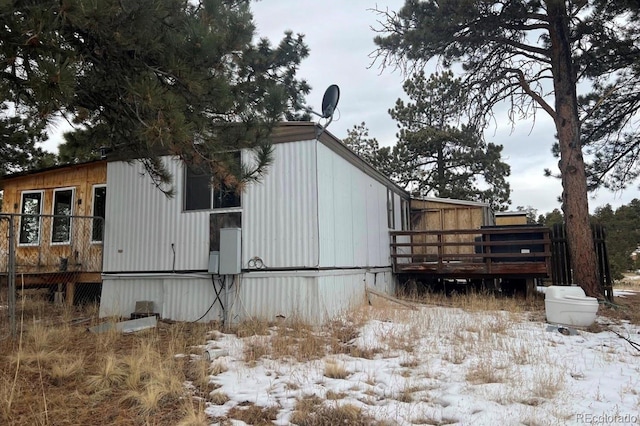 view of snowy exterior featuring a deck