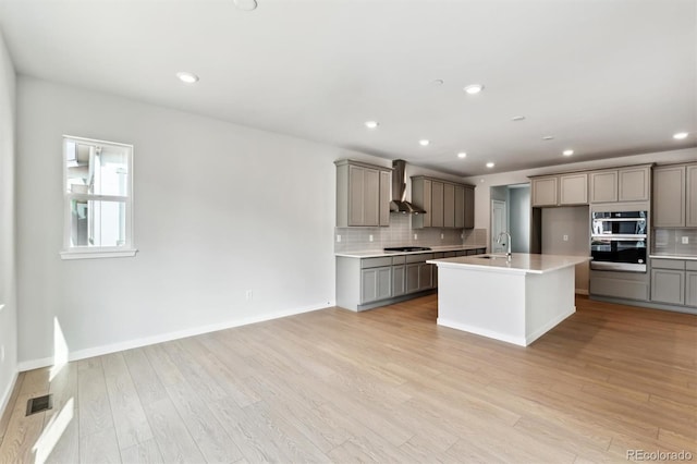 2536 Lupton Ln, Lafayette, CO 80026 - kitchen featuring gray cabinets, wall chimney range hood, backsplash, cooktop, and recessed lighting