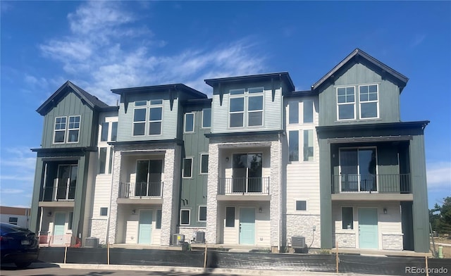 view of front of home with central AC and a balcony