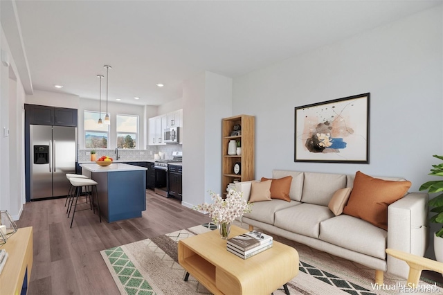 living room with sink and light wood-type flooring