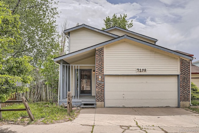 7198 Eaton Ct, Arvada, CO 80003 - view of front of home featuring driveway, a garage, and brick siding