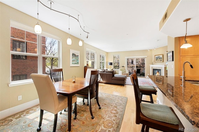 1560 Milwaukee St Unit 240, Denver, CO 80206 - dining area with light wood-style floors, a glass covered fireplace, and track lighting