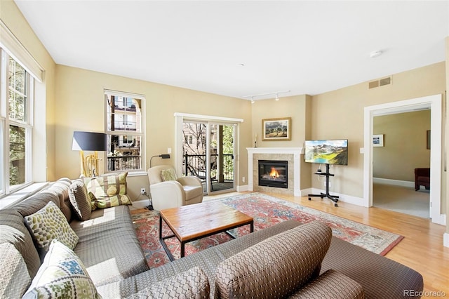 1560 Milwaukee St Unit 240, Denver, CO 80206 - living room featuring wood finished floors, rail lighting, a tile fireplace, and baseboards