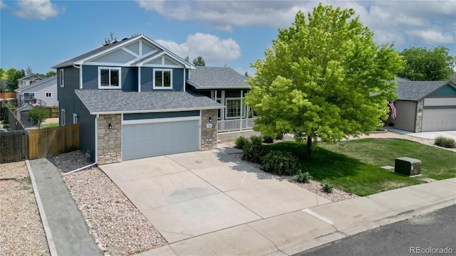 view of front of house featuring driveway, stone siding, fence, an attached garage, and a shingled roof