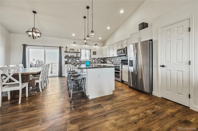 40051 Cold Iron Rd, Ramah, CO 80832 - kitchen with appliances with stainless steel finishes, a center island, dark countertops, a chandelier, and recessed lighting