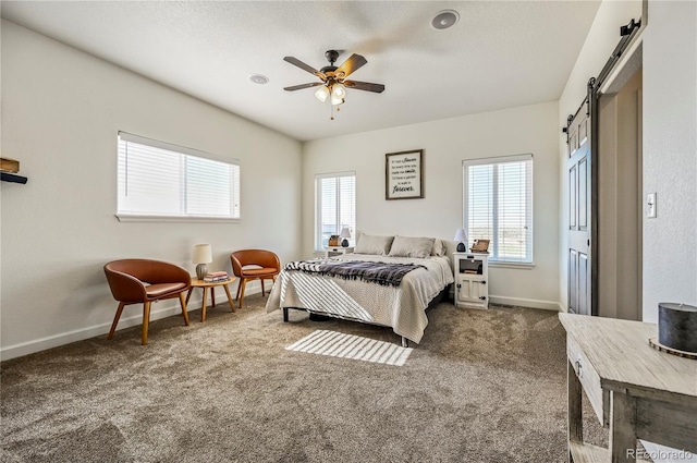 40051 Cold Iron Rd, Ramah, CO 80832 - bedroom with a barn door, dark colored carpet, baseboards, and ceiling fan