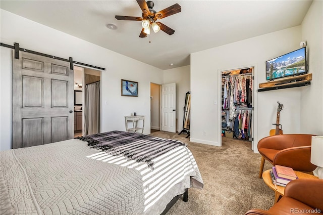 40051 Cold Iron Rd, Ramah, CO 80832 - bedroom featuring light carpet, a spacious closet, a barn door, baseboards, and a closet