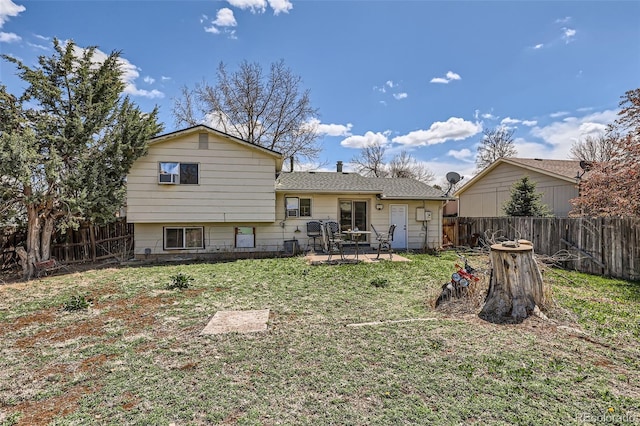 back of house with a lawn, a patio, a shingled roof, and a fenced backyard